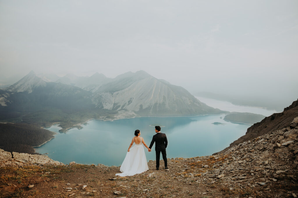 elopement couple overlooking a glacial lake in Kananaskis